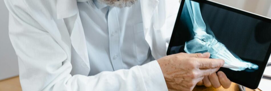 Senior doctor using tablet to explain X-ray results during an online consultation in a modern office.